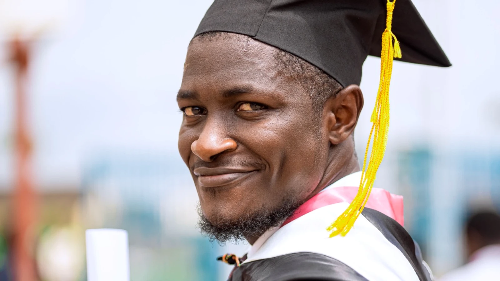 Young African graduate holding a qualification